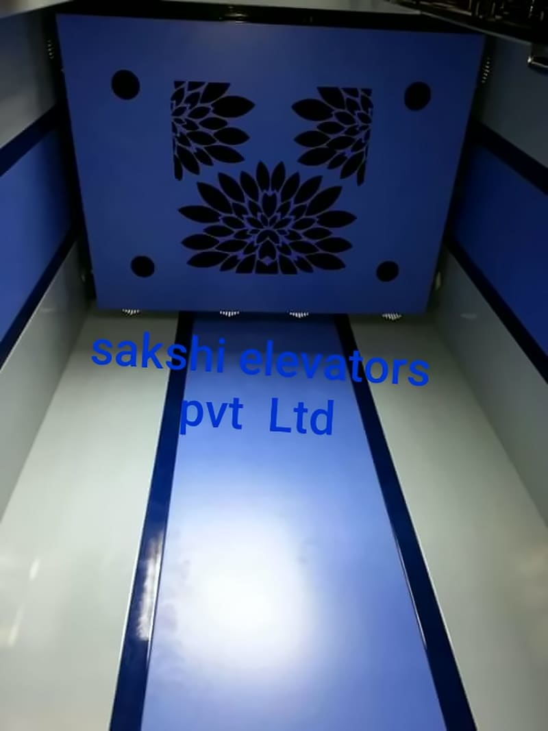 Lift cabin with blue wall panels, a blue floor strip and a decorative ceiling