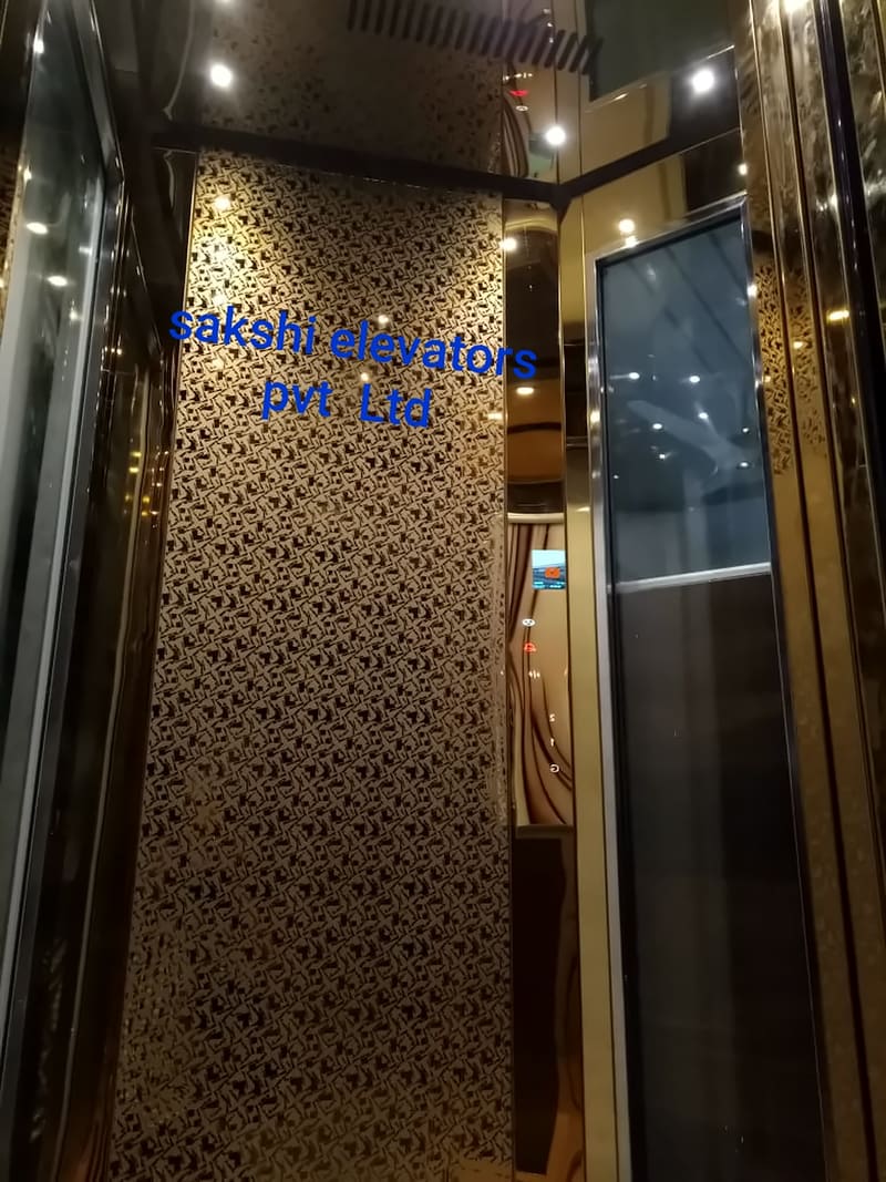 Lift cabin with a gold laser-cut jali rear panel and glass side walls